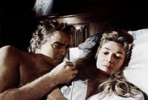 Marlon Brando et Stephanie Beacham au lit, la femme semble bouder ; scène du film Le corrupteur.