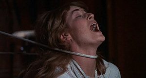 Stephanie Beacham en extase, tandis qu'une corde se resserre autour de son cou, scène du film Le corrupteur.