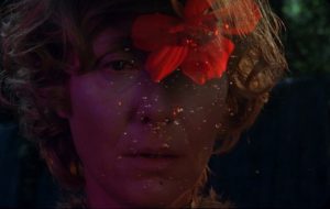 Une fleur rouge se dessine en surimpression sur le visage d'une femme de cinquante ans, scène du film Hormona.