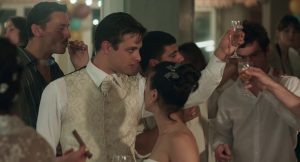 Un jeune homme lève son verre dans la scène de mariage du film Une vie violente.