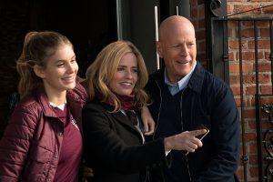 Paul Kersey (Bruce Willis) sur le perron de sa maison tout ourire avec sa femme et sa fille, scène du film Death Wish.