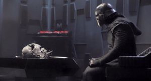 Kylo Ren, joué par Adam Driver, assis face au crâne de Dark Vador dans son vaisseau.