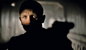 Daniel Craig dans un tunnel qui n'éclaire qu'une partie de son visage, braque son revolver sur une cible hors-champ, scène du film Skyfall, pour notre article sur le gadget dans le film d'espionnage.