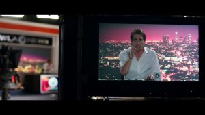 A l'arrière-plan à gauche, le plateau de télévision, à droite au premier plan, l'émission de Lou dans laquelle il pointe un doigt vers le spectateur, plan issu du film Night Call.
