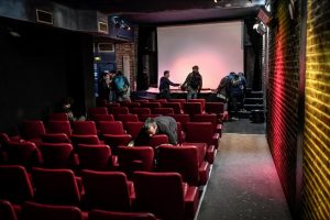 Des spectateurs nettoient la salle de projection du Cinéma Le Beverley après une séance.