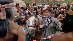 James Stewart explique son plan, au milieu de nombreux Amérindiens, scène du film La flèche brisée.