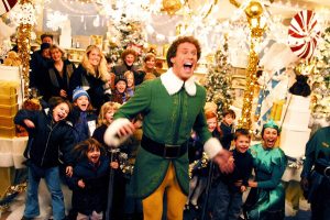 Will Ferrell en Elfe vert avec tout un groupe d'enfants joyeux.
