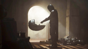 Boba Fett en contre-jour, au dessus d'un berceau en lévitation, scène de la série The Mandalorian.