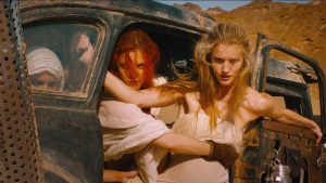 Les trois épouses d'Immortan Joe, dans la voiture rouillée avec laquelle elles ont pris la fuite, scène du film Max Max : Fury Road.