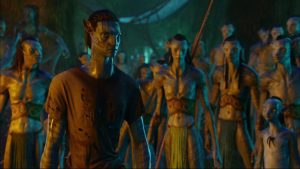 Jake Sully au premier plan, devant la tribu hostile et à la peau bleue de la planète Pandora, scène de nuit dans le film Avatar.