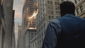 Batman alias Ben Affleck, vu de dos, observe les dégâts sur un immeuble de la bataille finale entre Superman et le Général Zod, scène du film Batman vs. Superman.