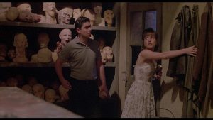 Un homme et une femme, personnages du film Waxwork, dans la salle où sont entreposés les bustes de cire.