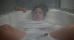 Un étrange objet appraît entre les jambes de Martha, jouée par Maren Jensen, détendue dans son bain.