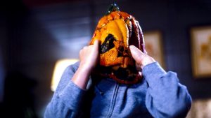 Une victime du film Halloween 3 tente d'enlever le masque maléfique de citrouille qui la fait souffrir.
