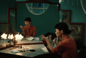 Lhéroïne du film Nina Wu, assise face à un miroir, dans une pièce aux murs bleus.