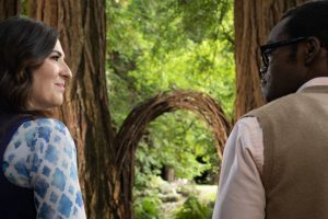 Janet et Chidi discutent face à face dans la forêt, scène de la série The Good Place.