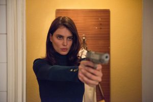L'actrice Catrinel Marlon vise qeulqu'un avec son revolver, sortant de la douche de sa chambre d'hôtel, scène du film Les Siffleurs.
