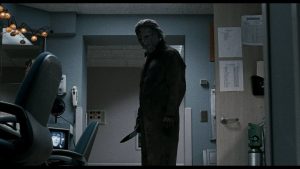 Michael Myers avec son couteau, dans la salle de surveillance vide de l'hôpital, scène angoissante du film Halloween II.