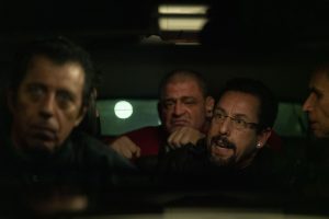 Howard retenu en otage par des malfrats à l'arrière d'une voiture roulant de nuit, scène du film Uncut Gems.