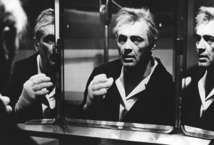 Rock Hudson vieillissant, cerné et fatigué face à trois miroirs, scène en noir en blanc du film L'opération diabolique de John Frankenheimer.