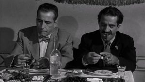 Harry Smith à table avec son acolyte syrien, scène du film Sirocco.