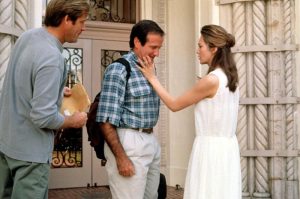 Jack, sac sur le dos, est réconforté par sa maman en robe blanche, sur le palier de leur luxueuse maison blanche, scène du film Jack de Francis Ford Coppola.