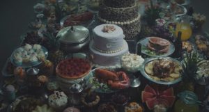 Une myriade de desserts exposée sur une table, scène du film La plateforme disponible sur Netflix.
