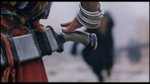 Gros plan d'une main s'apprêtant à dégainer une épee face à un ennemi arrivant en courant, flou à l'arrière-plan, scène du film The Blade de Tsui Hark.