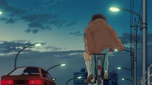 Shizuku de dos sur un vélo conduit par un garçon sur un pont, passe une voiture à côté d'eux sur la gauche, scène de nuit dans le film Si tu tends l'oreille.