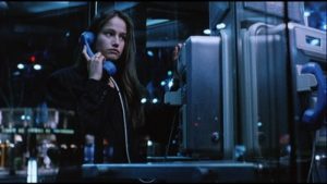 Dans une cabine téléphonique, la nuit, Marie Gillain est au combiné, avec une moue boudeuse, scène du film L'appât pour notre critique.