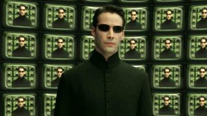 Néo devant un mur d'écran qui reproduisent son image, scène de la saga Matrix.