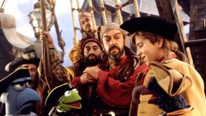 Kermit au milieu des pirates sur le pont d'un bateau, dans le film L’île au trésor des Muppets.