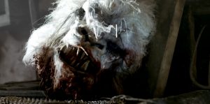Une tête coupée de monstre proche d'un bélier gît sur le sol dans le film The HEad Hunter.