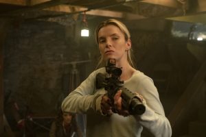 L'héroïne de The Hunt prête à tirer avec une arme d'assaut, scène dans un garage dans le film The Hunt.