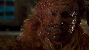 Un homme au visage mi-humain mi-monstre visqueux, scène du film Horribilis.