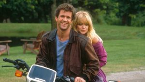 Mel Gibson et Goldie Hawn posent tout sourire sur une moto pour la promotion de Comme un oiseau sur la branche.