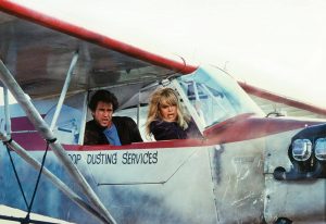 Goldie Hawn - en pilote - et Mel Gibson - à l'arrière - inquiets dans un avion biplace qui peine à decoller, scène du film Comme un oiseau sur la branche.