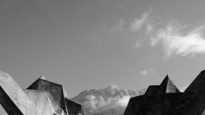 Paysage en noir et blanc, ciel bleu au dessus de montages aux formes étonnamment géométriques et des sommets aux angles pointus, ce sont en fait les Spomenici yougoslaves ; plan du film Last and first men.