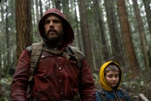 Le père (Casey Affleck) et sa fille Rag marchent dans la forêt capuche relevée sur la tête dans le film Light of my life.