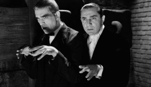 Bela Lugosi et Boris Karloff les mains en avant, dans une posture inquiétante en clair-obscur, scène du film le corbeau de 1935.