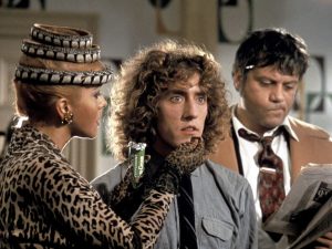 Une femme en tenue chic, motifs léopard, pose sa main sous le menton d'un Roger Daltrey les yeux dans le vide, scène du film Tommy.