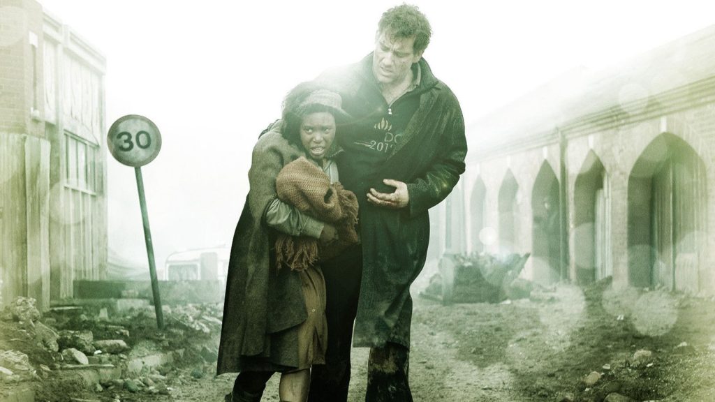 Theo tient dans ses bras Kee dans une rue en ruines, scène du film Les fils de l'homme.