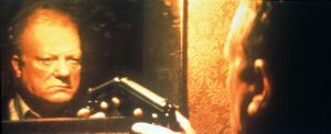 Philippe Nahon pointe un revolver contre son propre reflet dans le miroir, scène du film Seul contre tous de Gaspar Noé.