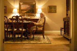 Edna au dîner, seule au bout d'une longue table et dans un salon vide,scène du film Relic.