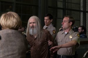 Un viel homme barbu aux longs cheveux gris est arrêté par un trois policiers en pleine rue dans le film 3 from Hell.