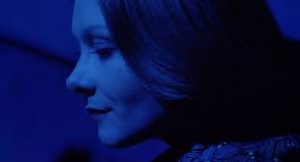 Gros plan sur le visage de Macha Méril sous une intense lumière bleue, issu du film La bête tue de sang froid.
