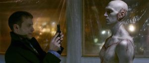 Henry (David Call) totu fier prend en photo avec son smartphone le Frankenstein chauve et jeune qu'il vient de créer, scène du film Depraved.