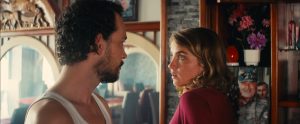 Jonatha Couzinié et Adèle Haenel échangent un regard regard intense, dans un salon boisé, plan du film Les héros ne meurent jamais d'Aude Léa Rapin.