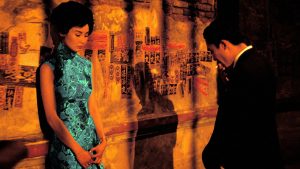 Tony Leung face à Maggie Cheung, adossée à un mur jauni par la lumière factice de la ville de nuit, scène du film In the mood for love pour notre entretien avec Nathalie Bittinger.