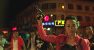 Zhao Tao tire en l'air en pleine rue nocturne pour faire cesser une bagarre dans le film Les éternels.